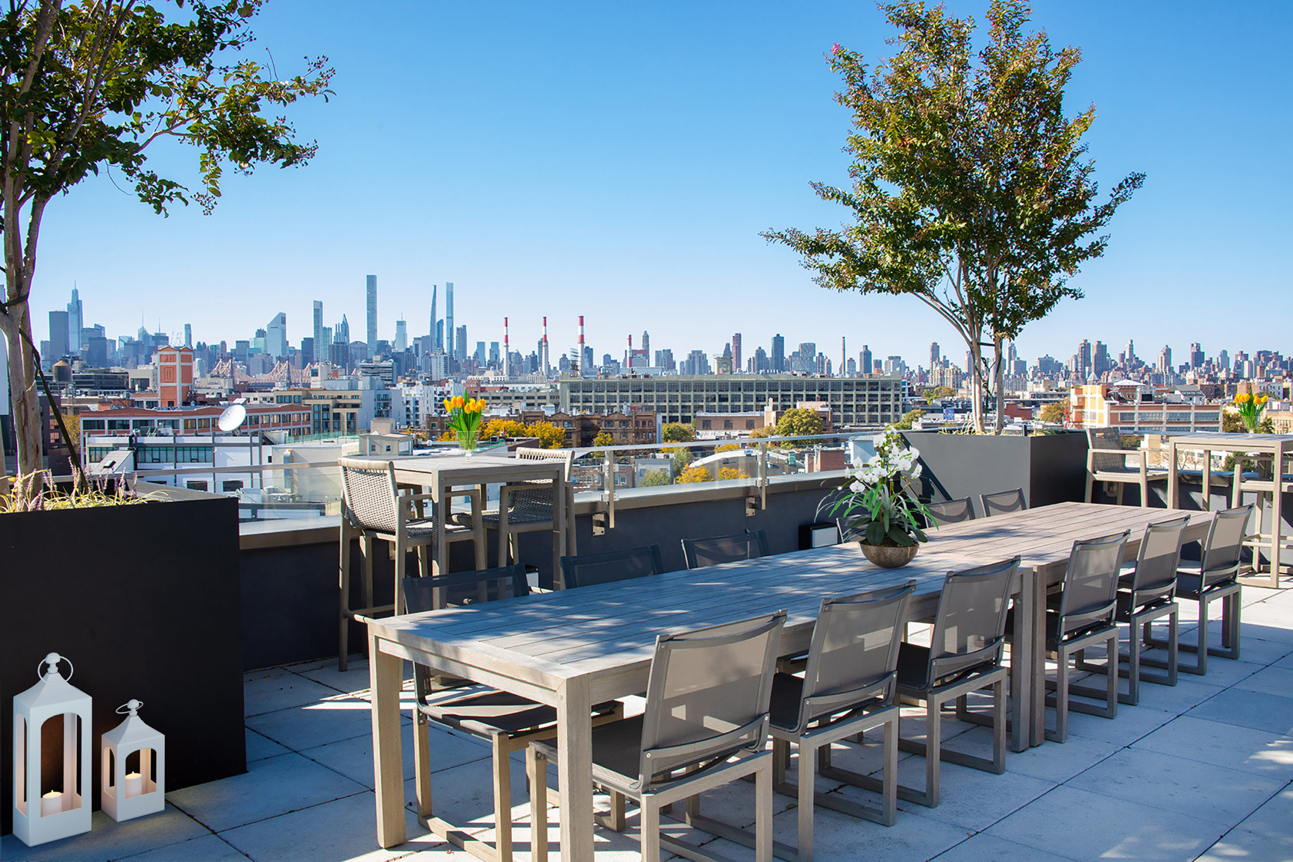 Roof deck with city views, long shared dining seating, high top tables and trees